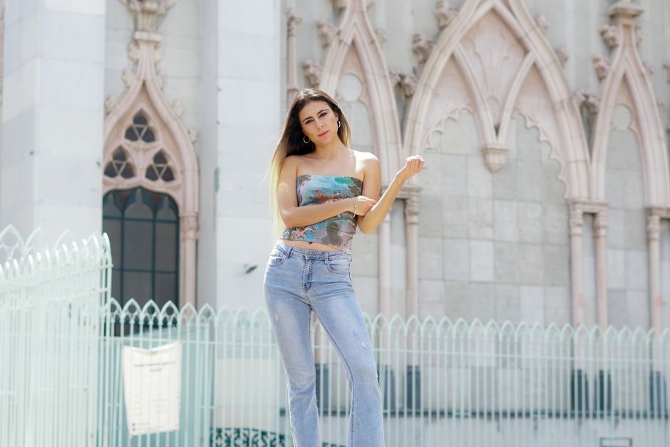 Stylish woman posing in front of gothic architecture in León, México.